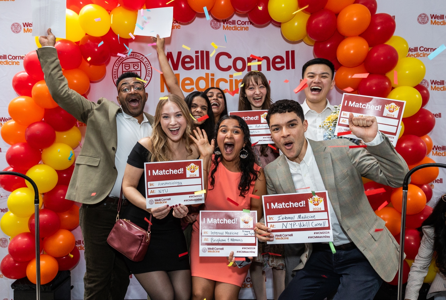 Group photo of celebrating students surrounded by balloons
