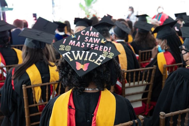 a graduating student posing for a photo to show off their graduation cap