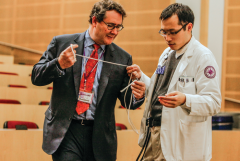 Seeing is Believing: Dr. Rosenkranz attired for his magic act working with a student.